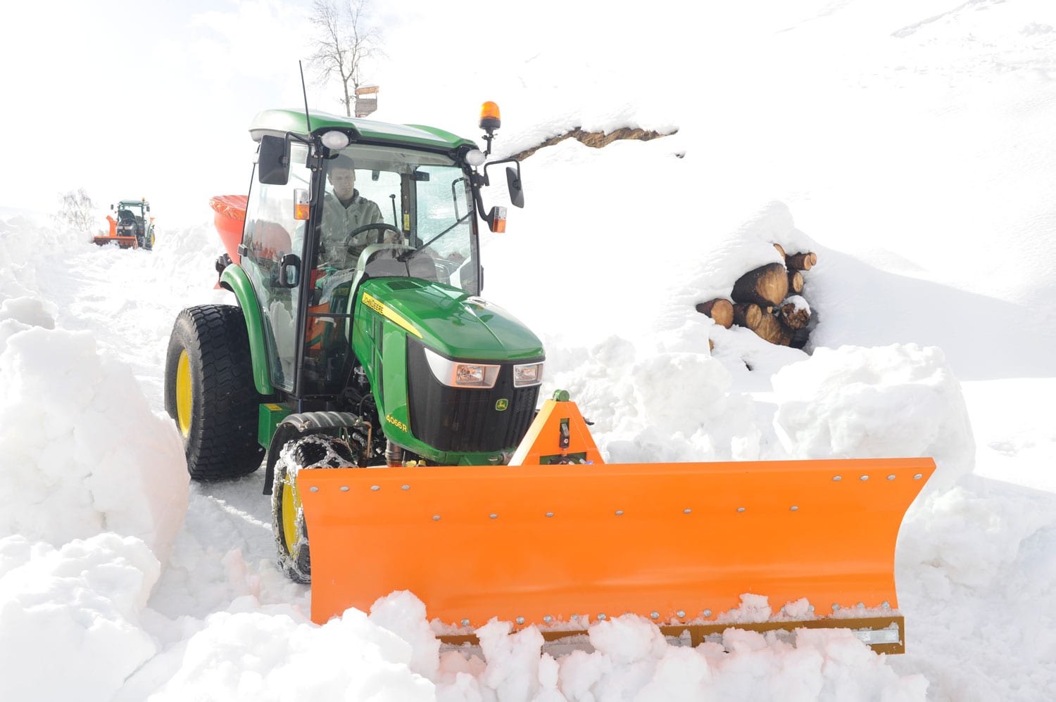 Kompakttraktor mit Schneeschild im Winterdienst auf einer geräumten Zufahrt